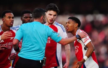 Arsenal players surround Michael Oliver