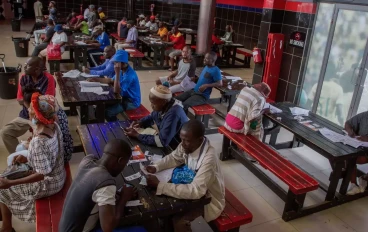 Customers place their bets and watch screens inside a sports betting shop in the Soweto township of Johannesburg