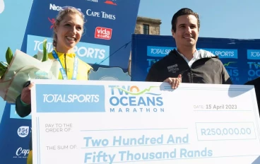 Gerda Steyn winner of the Women’s Ultra Marathon in a new course record celebrates with a bonus from Totalsports during the 2023 Totalsports Two Oceans Ultra Marathon finishing at UCT Rugby F