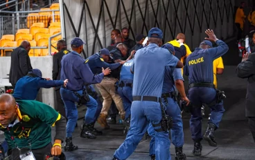 Former Kaizer Chiefs coach Molefi Ntseki escorted by police after fans throwing objects on him during the Carling Knockout match between Kaizer Chiefs and AmaZulu FC at FNB Stadium on October