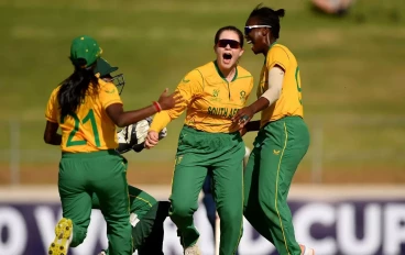 Madison Landsman of South Africa celebrates after taking the wicket of Orla Montgomery of Scotland with teammates Seshnie Naidu and Oluhle Siyo of South Africa during the ICC Women's U19 T20