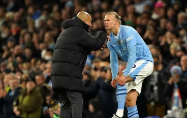 Manchester city manager Pep Guardiola speaks with Erling Haaland