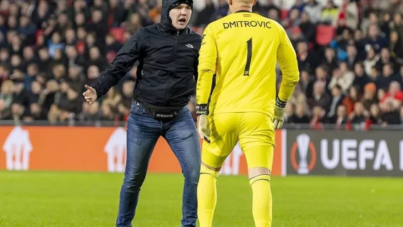 Sevilla goalkeeper Marko Dmitrovic attacked by pitch invader in PSV clash